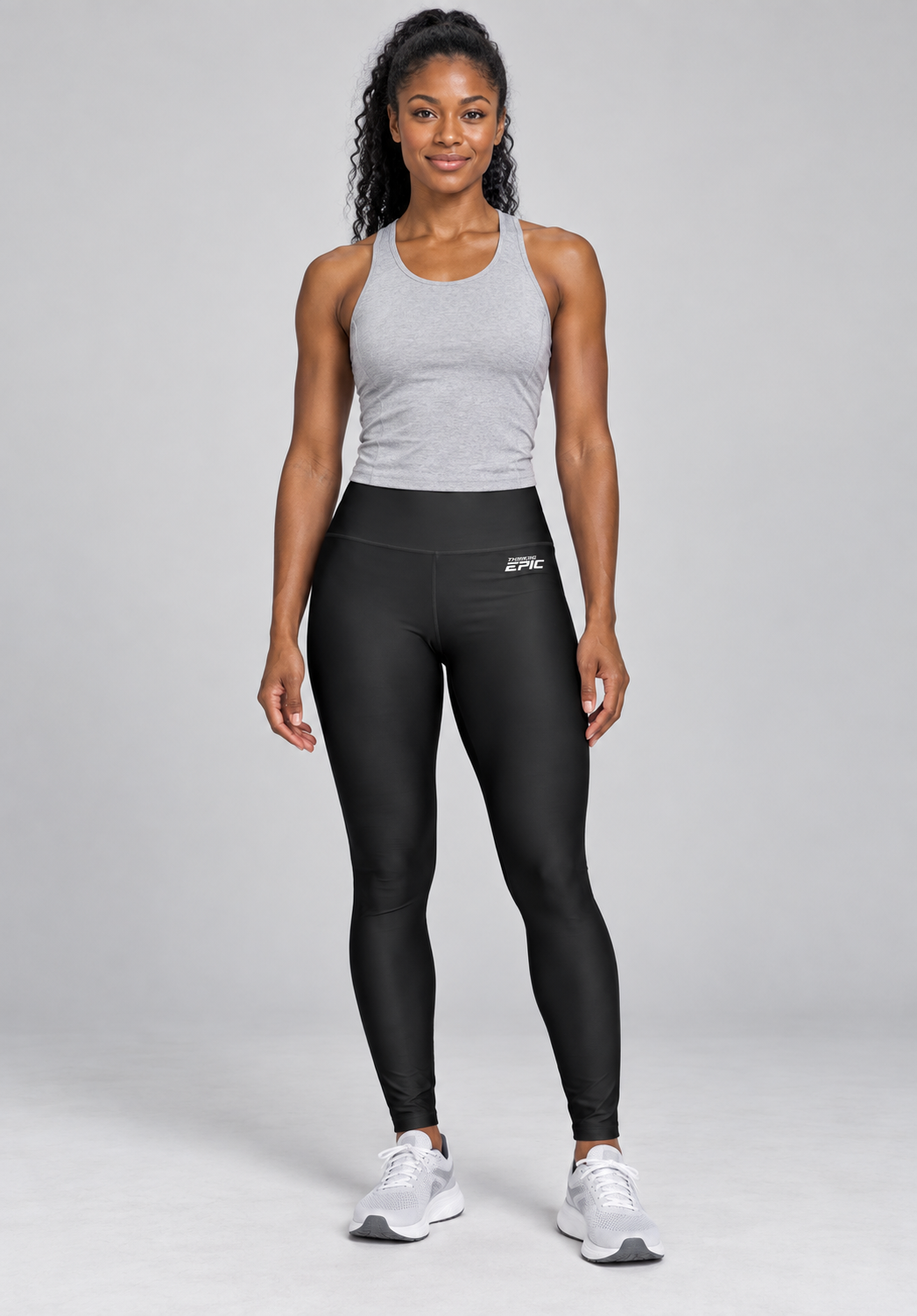 Woman wearing black high-waisted Thinking Epic leggings with a grey tank top